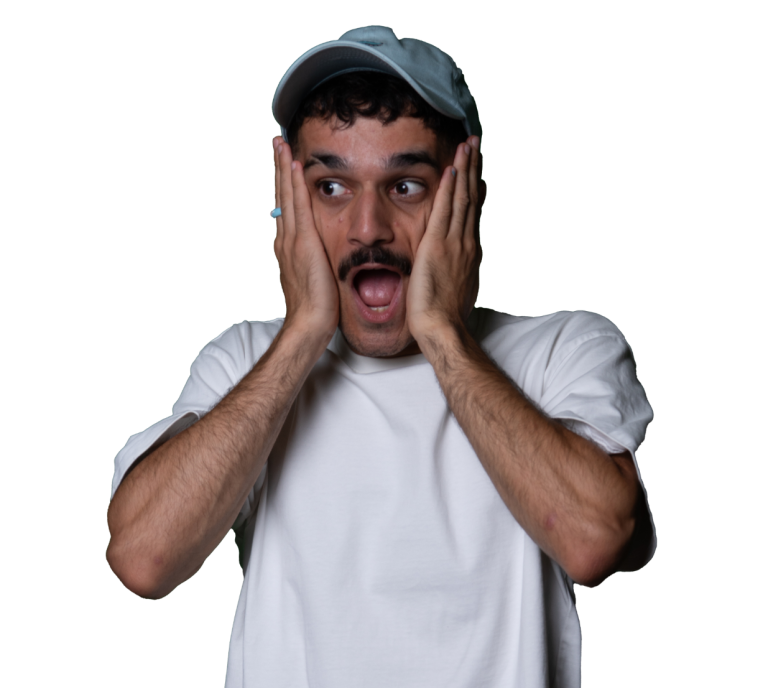 Een man met een pet, met open mond en handen op zijn wangen, toont verrassing.